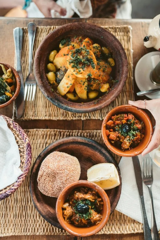 Moroccan tagine, salads, bread and tea arranged for a shared meal