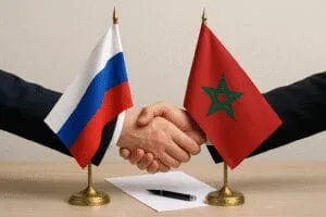 Handshake between tabletop flags of Russia and Morocco