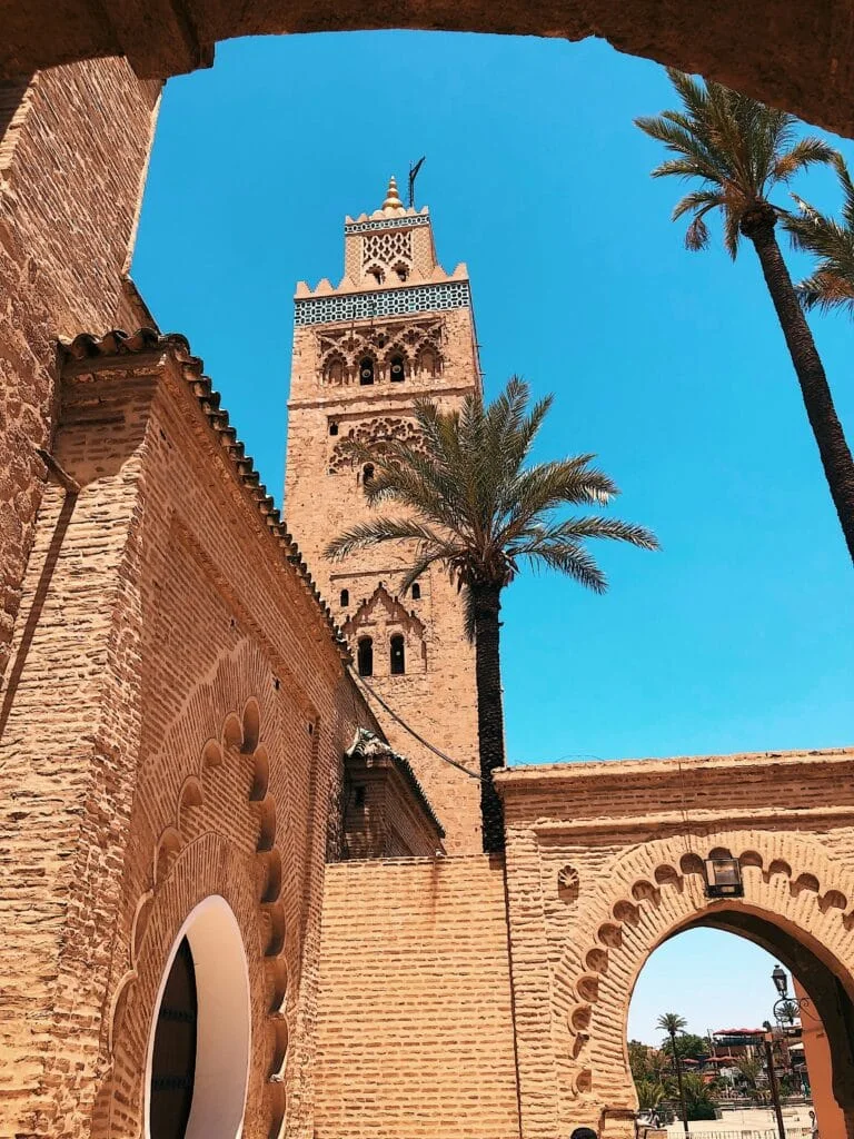 Visitors walking through a sunlit street in Marrakech
