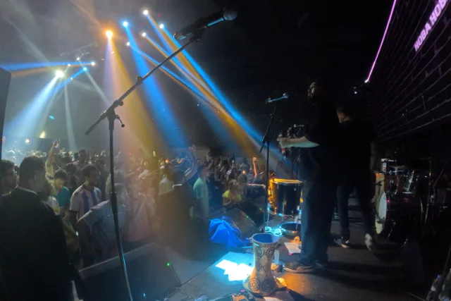 Live music event in Marrakech with a full crowd and colorful stage lights, boosting tourism and property rental demand.