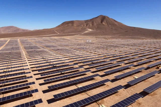 Solar panels in Morocco desert showing renewable energy projects supporting real estate development.